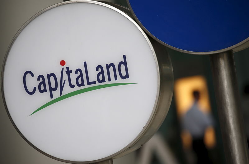 © Reuters. A man passes a Capitaland logo outside an office building in the central business district in Singapore