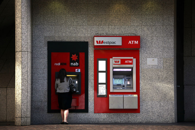 © Reuters. A Westpac automated teller machine (ATM) can be seen next to a woman as she uses a National Australia Bank ATM in central Sydney