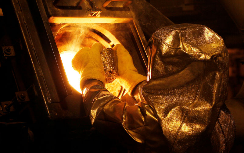 © Reuters. FILE PHOTO: Senior refinery technician puts a gold "button" into a furnace to be further refined to form gold dore bars at Newmont Mining's Carlin gold mine operation near Elko, Nevada