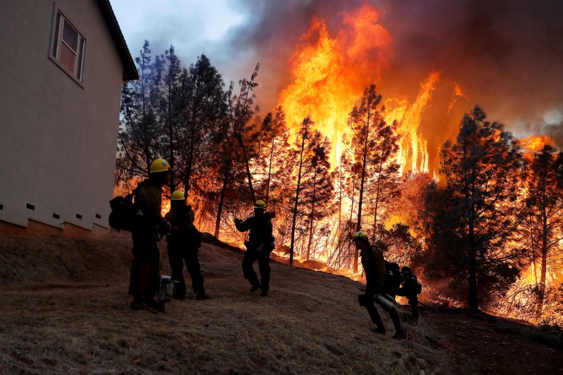© Reuters. Bombeiros combatem chamas para tentar salvar casa em Paradise, na Califórnia