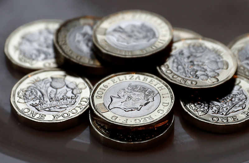 © Reuters. New one pound coins which comes into circulation today, are seen in Liverpool