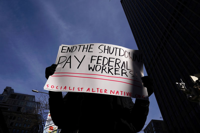 © Reuters. Manifestante segura uma placa durante protesto contra a paralisação parcial do governo em frente a um prédio público federal fechado em Nova York