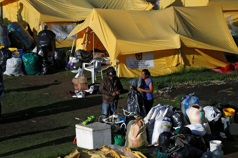© Reuters. Foto del martes de una familia de migrantes venezolanos arreglando sus pertenencias al lado de una carpa en un campo de ayuda humanitaria en Bogotá que está siendo cerrado por el gobierno