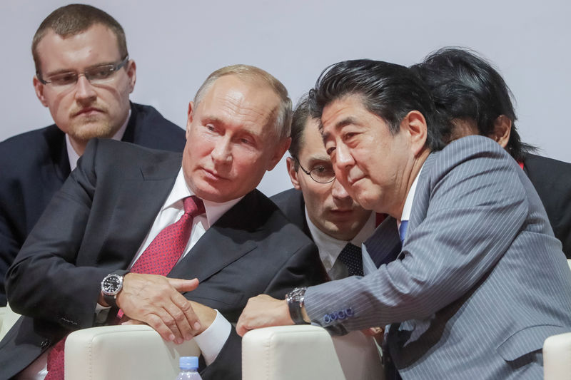 © Reuters. Президент России Владимир Путин и премьер-министр Японии Синдзо Абэ на международных соревнованиях по дзюдо во Владивостоке
