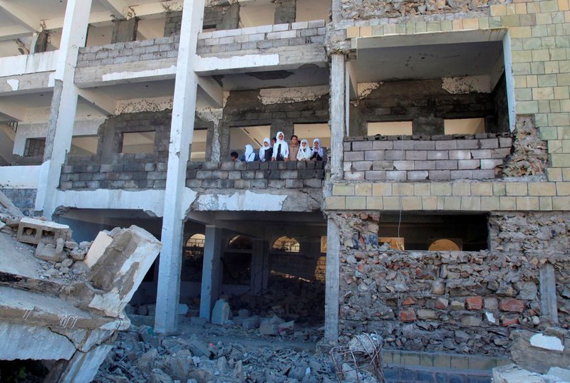 © Reuters. عودة الدراسة بمدرسة تعرضت للقصف في اليمن مع صرف رواتب المعلمين