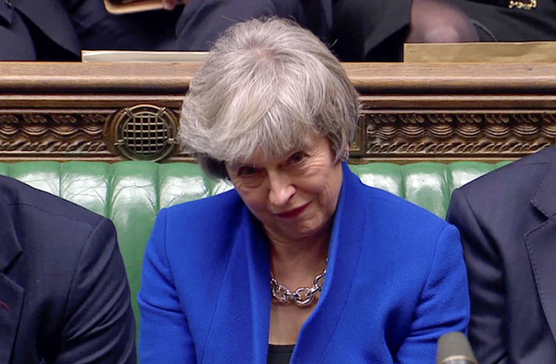 © Reuters. British Prime Minister Theresa May reacts as Jeremy Corbyn speaks, after she won a confidence vote, after Parliament rejected her Brexit deal, in London
