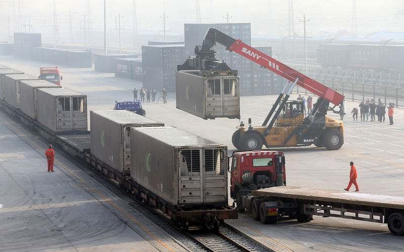 © Reuters. Workers unload containers from a train at Dahongmen Railway Station in Beijing