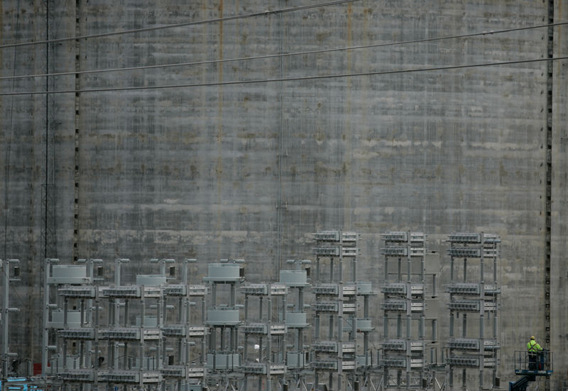 © Reuters. Alcoa employee works on a crane in front of an alumina silo in Alcoa Fjardaal aluminium smelter