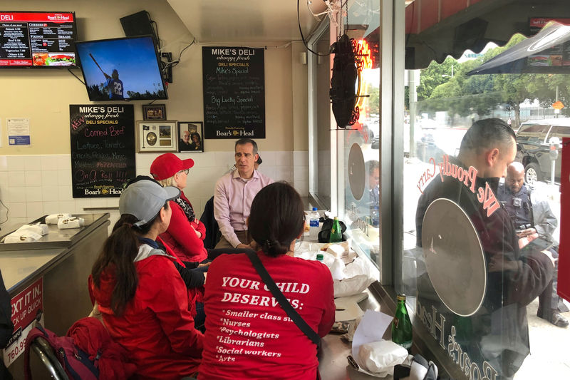 © Reuters. Los Angeles Mayor Eric Garcetti sits at a deli counter and talks with striking teachers in downtown Los Angeles