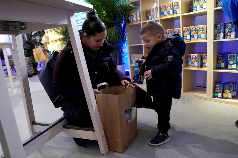 © Reuters. FILE PHOTO: A federal worker left unpaid or furloughed collects a free bag of groceries with a child from Kraft Foods on the 27th day of the partial government shutdown in Washington