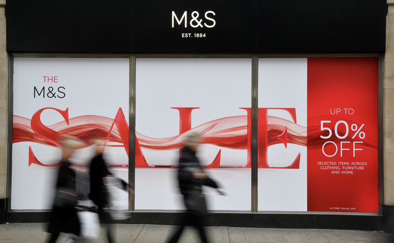 © Reuters. Shoppers walk past sale signs at Marks and Spencer on Oxford Street in London