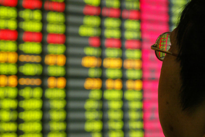 © Reuters. Investidor observa tela com movimento de mercados em Xangai