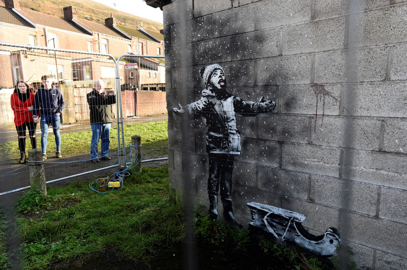 © Reuters. FILE PHOTO: People view new Banksy image in Port Talbot