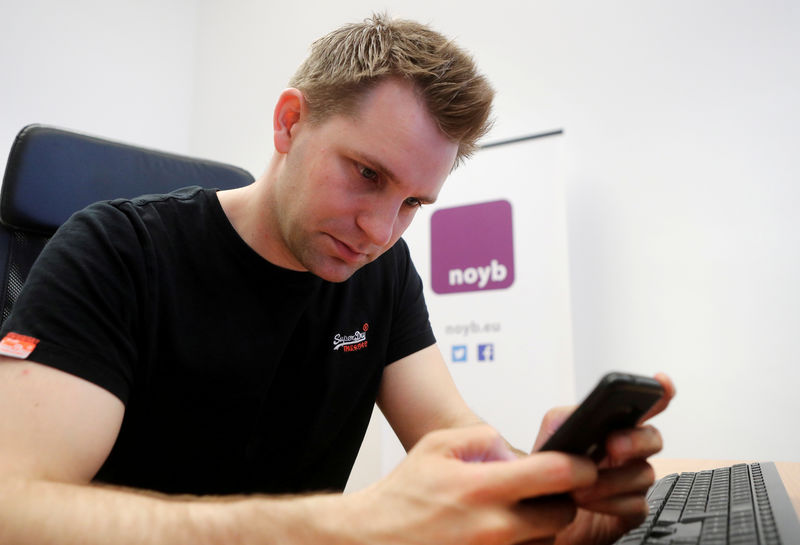 © Reuters. FILE PHOTO: Austrian lawyer and privacy activist Schrems checks his mobile phone in his office in Vienna