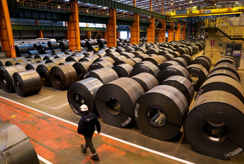 © Reuters. FILE PHOTO:  A worker walks past steel rolls at the ArcelorMittal steel plant in Sestao