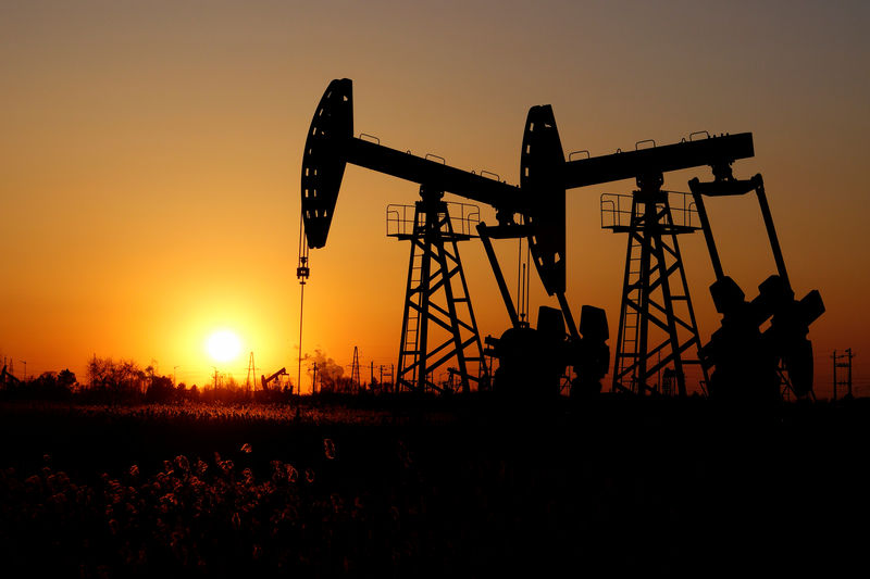 © Reuters. Pumpjacks are seen against the setting sun at the Daqing oil field in Heilongjiang