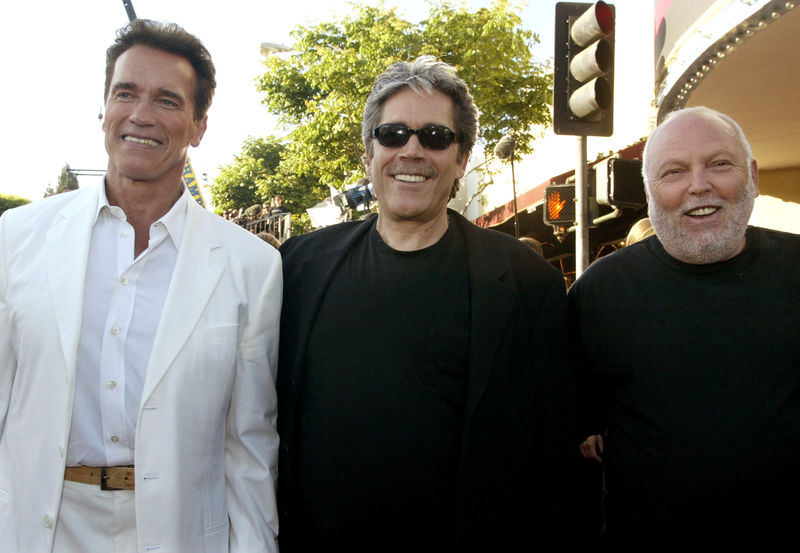 © Reuters. FOTO DE ARCHIVO:  El actor Arnold Schwarzenegger posa con los productores  Mario Kassar (centro) y Andrew Vajna (derecha) en un estreno en Los Angeles, 30 de junio del 2003. REUTERS/Fred Prouser/Foto de archivo