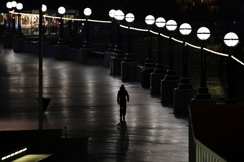 © Reuters. A commuter walks to work along the River Thames, in London