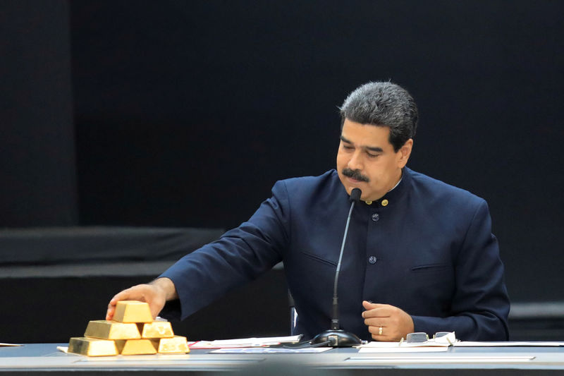 © Reuters. FILE PHOTO: Venezuela's President Nicolas Maduro touches a gold bar as he speaks during a meeting with the ministers responsible for the economic sector at Miraflores Palace in Caraca