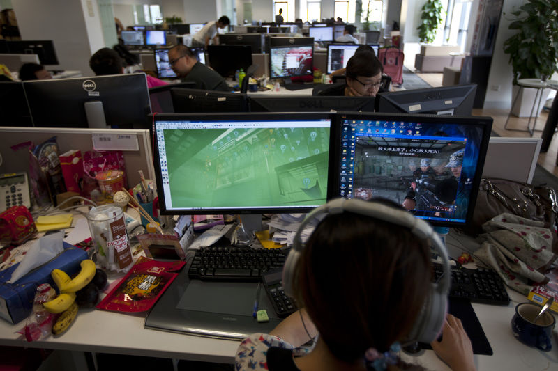 © Reuters. An employee watches a computer screen displaying the video game "Glorious Mission Online" at the game developer's office in Shanghai