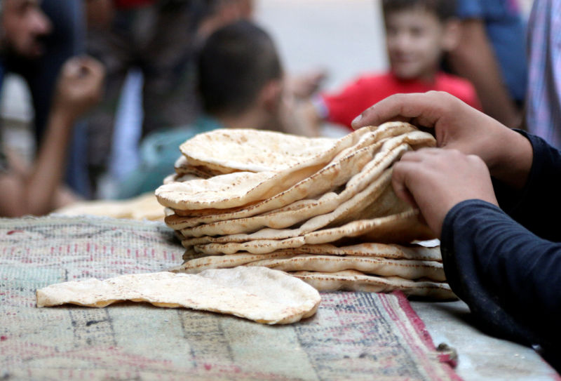 © Reuters. Мальчик раскладывает хлеб в Алеппо