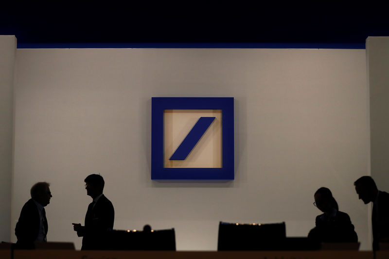 © Reuters. People are silhouetted next to the Deutsche Bank's logo prior to the bank's annual meeting in Frankfurt