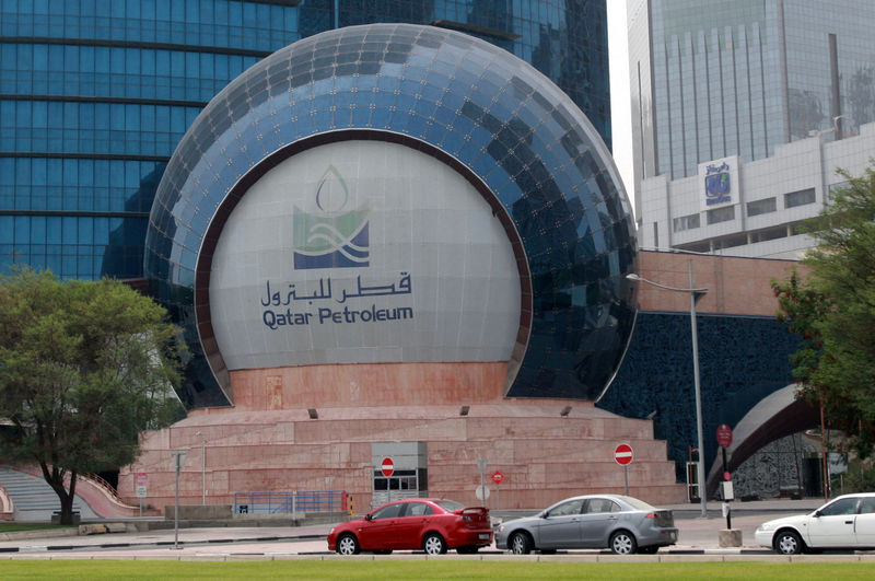 © Reuters. FILE PHOTO: Cars are parked outside the headquartes of Qatar Petroleum in Doha