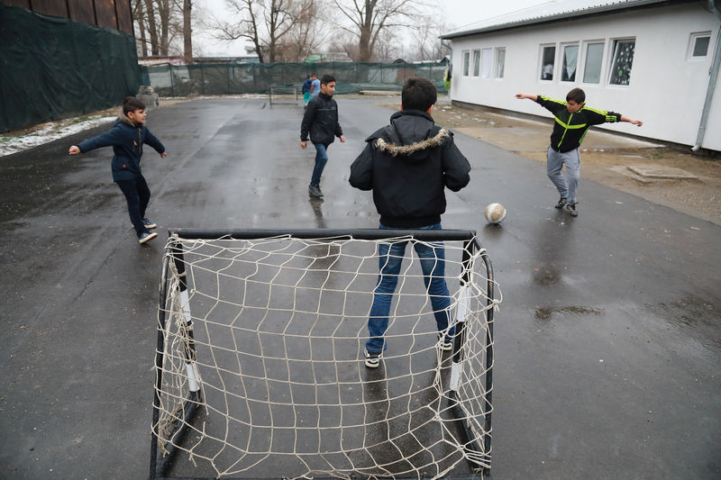 © Reuters. Crianças jogam bola em campo para imigrantes e refugiados perto de Belgrado