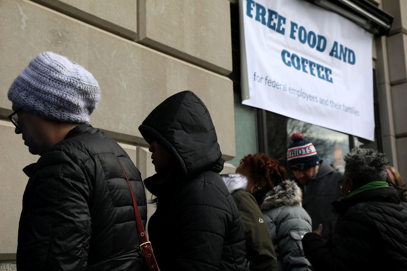 © Reuters. Federal workers left unpaid or furloughed by the extended partial government shutdown stand in line for fresh food and coffee at the World Central Kitchen in Washington