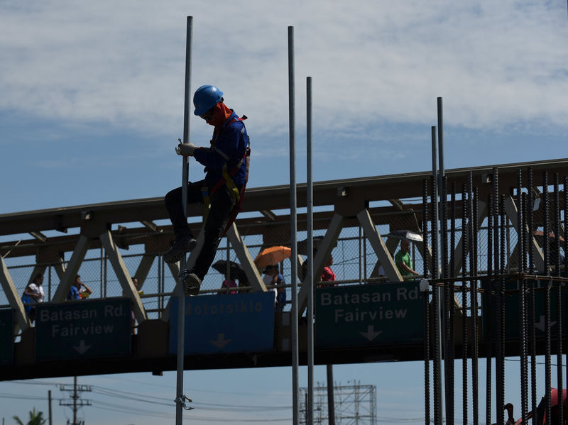 © Reuters. A worker assembles a pole at a construction site of the Metro Rail Transit (MRT)