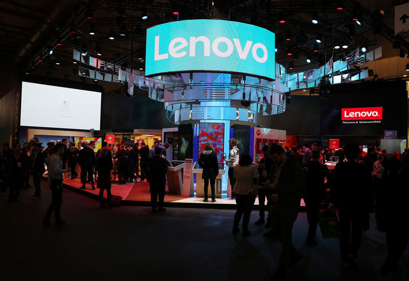 © Reuters. FILE PHOTO - Visitors attend the Lenovo booth at the Mobile World Congress in Barcelona