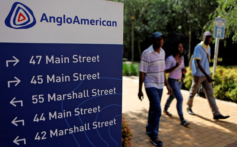 © Reuters. FILE PHOTO: People walk past a board outside the Anglo American offices in Johannesburg