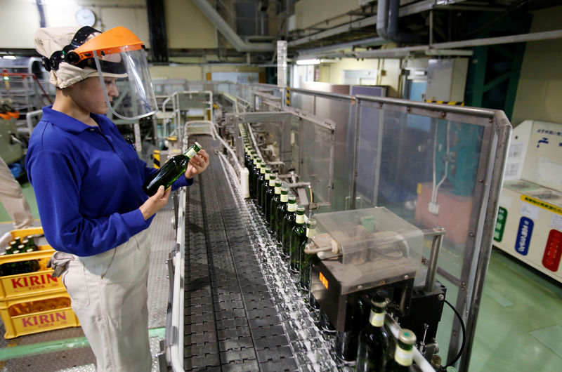 © Reuters. Un'operaia a lavoro in una fabbrica di birra giapponese