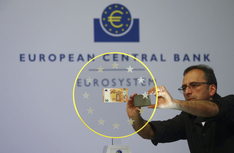 © Reuters. A journalist takes a picture of the new 50 Euro banknote at the ECB headquarters in Frankfurt