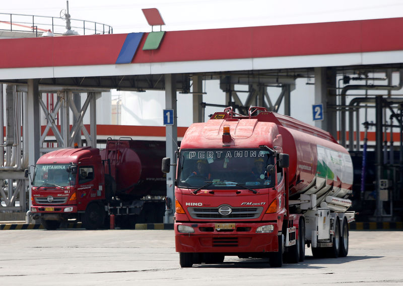 © Reuters. FILE PHOTO: A fuel truck passes storage tanks as it departs after loading its cargo at a state-owned Pertamina fuel depot in Jakarta