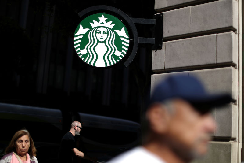 © Reuters. FILE PHOTO - People walk past a Starbucks store in Los Angeles