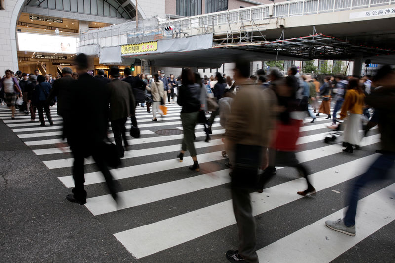 © Reuters. Commuters cross a pedestrian crossing in Osaka