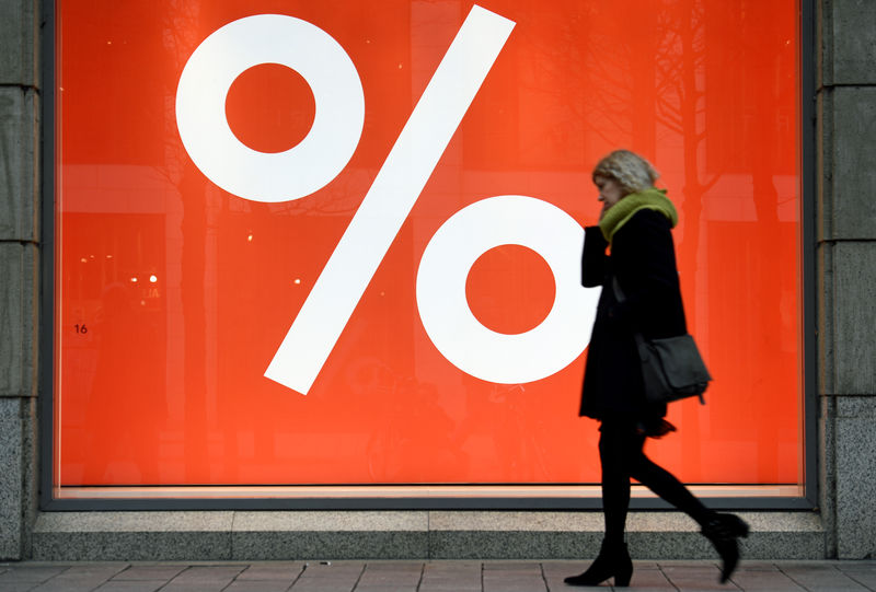 © Reuters. A woman passes a sale sign in a shop window in downtown Hamburg