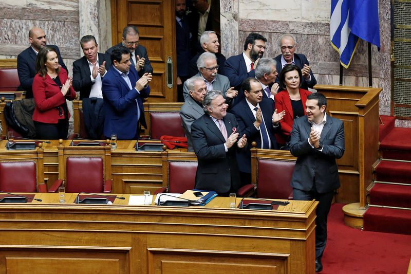 © Reuters. Greek PM Tsipras and members of his government applaud after a vote during a parliament session in Athens