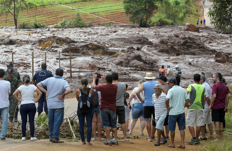 © Reuters. Residents are seen on a road blocked after a dam, owned by Brazilian miner Vale SA, burst in Brumadinho