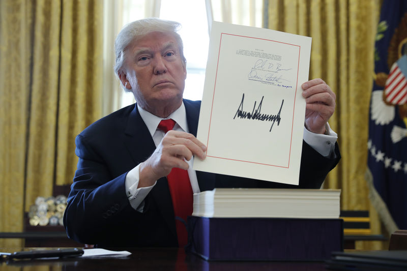 © Reuters. U.S. President Trump displays signbature after signing tax bill into law at the White House in Washington