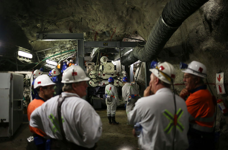 © Reuters. Mine workers are seen in front of a giant drill-cum-vacuum cleaner that accelerates drilling at an underground tunnel at Cullinan mine outside Pretoria, northeast of Johannesburg