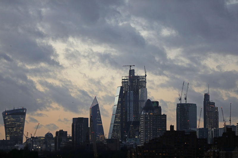 © Reuters. The sun sets behind the Canary Wharf financial district of London