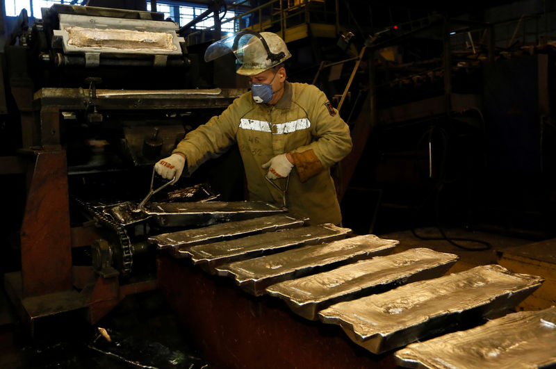 © Reuters. A worker controls forming of aluminium ingots on a conveyor belt at the foundry shop of the Rusal Krasnoyarsk aluminium smelter in Krasnoyarsk