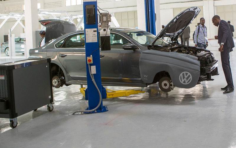 © Reuters. A visitor looks at a the motor of a vehicle inside the first domestically built car rolled off the assembly line at Volkswagen's new factory in Kigali