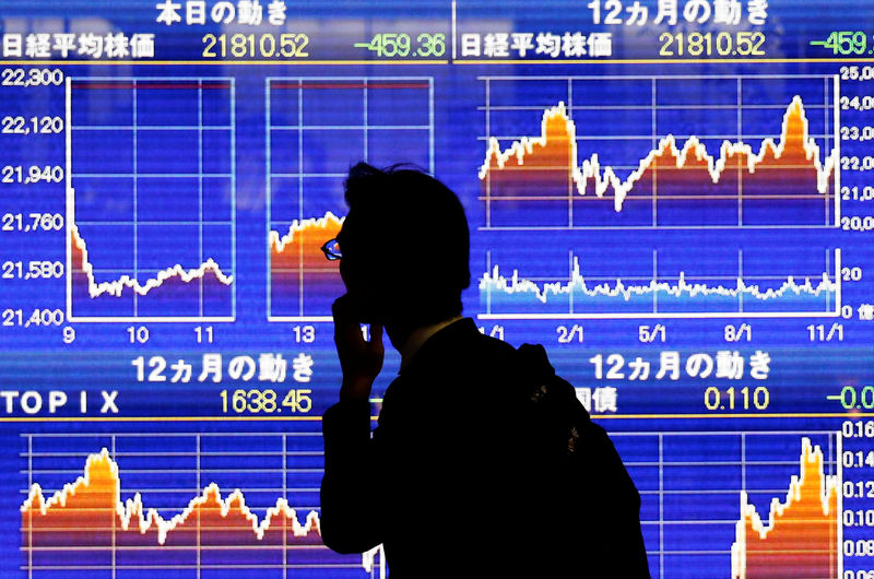 © Reuters. A man looks at an electronic stock card showing Japan's Nikkei average outside a brokerage in Tokyo