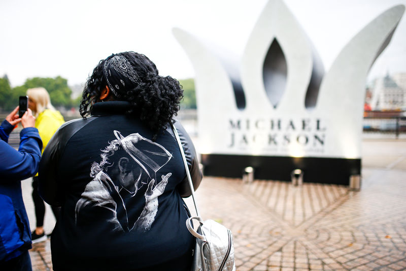 © Reuters. Imagen de archivo de un grupo de fans de Michael jackson fotografiando una corona gogante instalada en Londres para celebrar el cumpleaños 60 del "Rey del Pop"