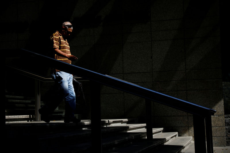 © Reuters. Un hombre camina a las afueras de un banco en Caracas