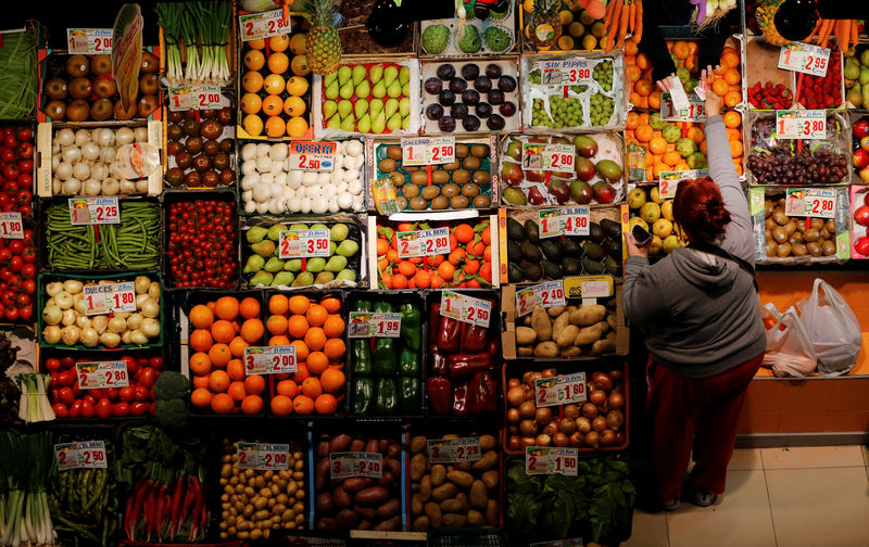 © Reuters. FILE PHOTO - A woman shops at a fruits and vegetables shop at a food market in the Andalusian capital of Seville, southern Spain