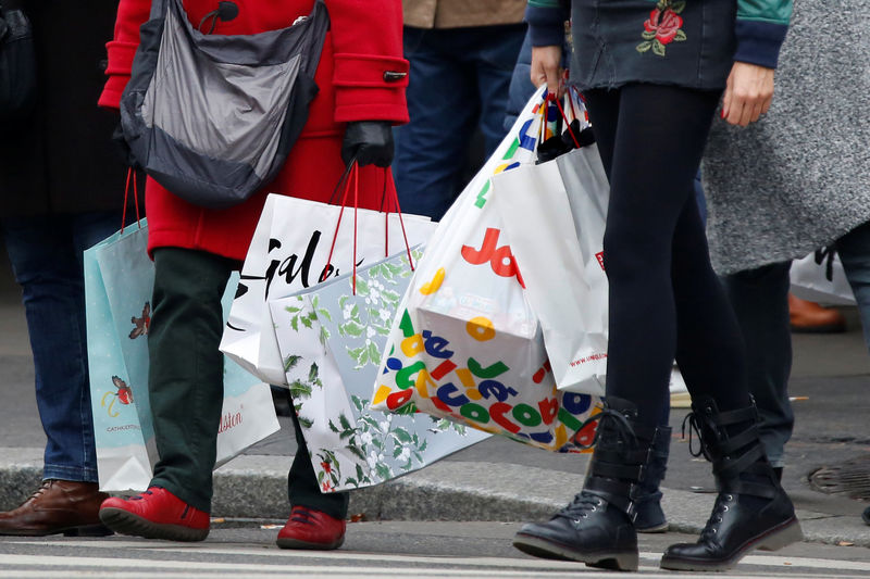 © Reuters. Shoppers carry shopping bags as they take care of their last-minute Christmas holiday gift purchases outside department stores in Paris